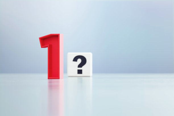 红色1号和问号写的白色立方体坐在离焦的背景前图片下载
