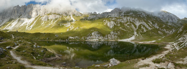 秋季在Laghi d’olbe的主湖和绿色湖水的美丽全景，白天被美丽的岩石和绿色的草坡山脉所包围图片下载