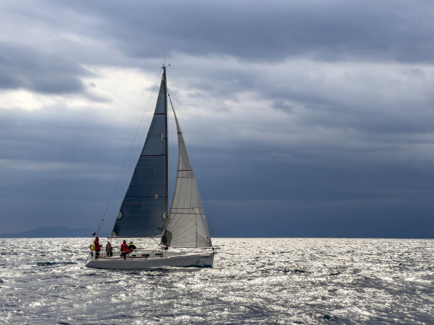 在寒冷的冬日里，船长和水手们驾着帆船，以天空和大海为背景图片下载