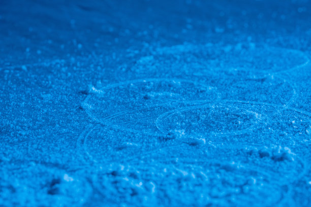 冰背景和纹理与划痕从滑冰和曲棍球。溜冰场地板，纹理冰背景与雪和晶体在蓝光的细节。空荡荡的溜冰场关闭图片下载