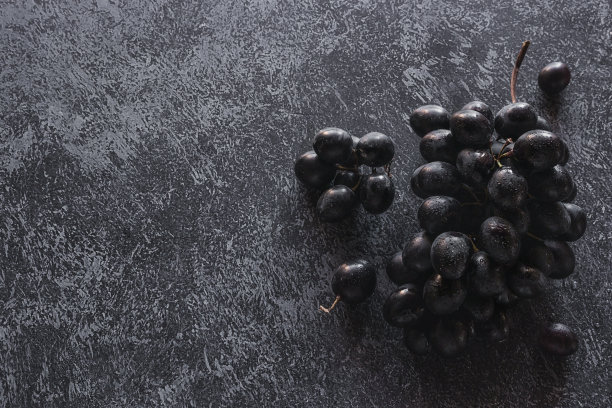 一串黑色的葡萄在黑色的背景与文本空间图片下载