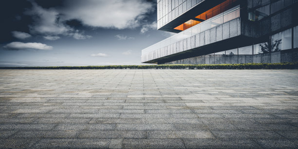 在晴空万里的天空下，城市中心的建筑物后面是石砌的广场图片下载