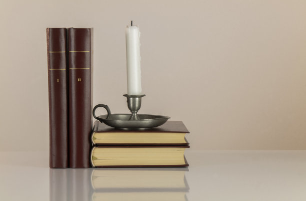 白色背景下的烛台和老式书籍图片下载