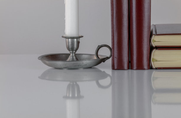 白色背景下的烛台和老式书籍图片下载