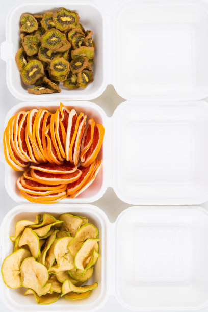 白色塑料容器里有干果、苹果、猕猴桃和葡萄柚，特写照片，上面有题字图片下载