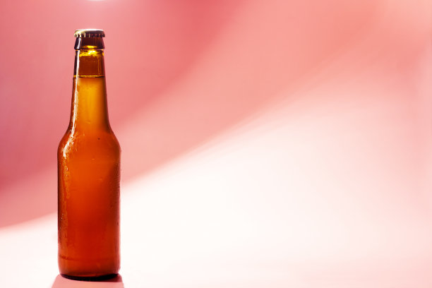封闭的啤酒瓶粉红色背景与阴影图片下载