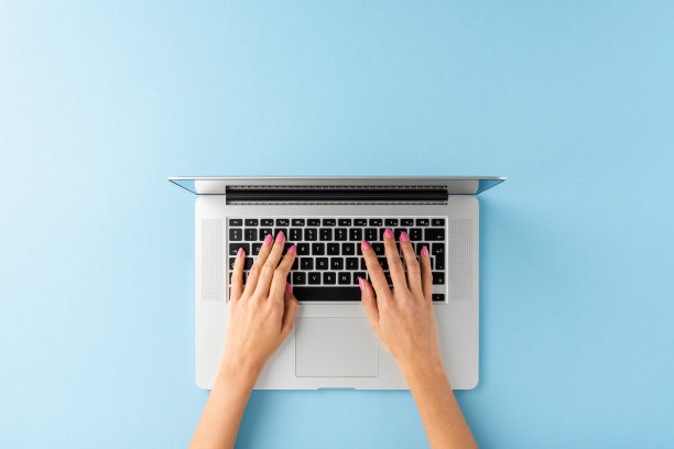 女人的手在笔记本电脑上工作。业务背景与copyspace。俯视图图片下载