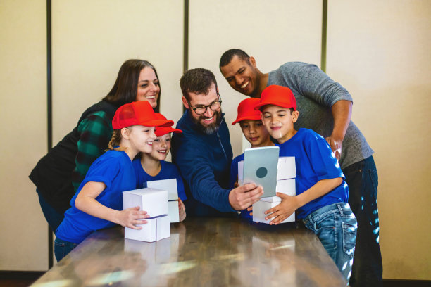 帮助和鼓励青少年棒球队多元文化的男女儿童与父母一起策划和准备募捐活动照片系列图片下载