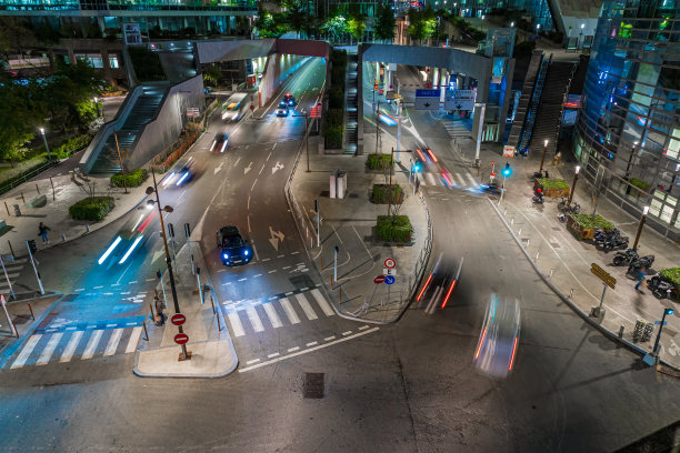 拉德芳斯区夜晚的十字路口，有建筑物和树木图片下载