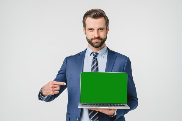 白人年轻自信的商人指着电脑笔记本屏幕上显示的绿色模型copyspace为电子学习，远程工作，在线应用隔离在白色背景图片下载