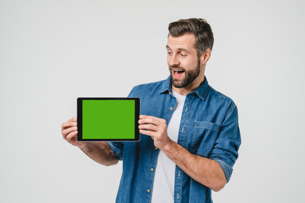 绿色模型屏幕广告copyspace空闲空间。一名白人年轻人手持数码平板电脑，在屏幕上显示手机应用程序，在线社交媒体被隔离在白色中图片下载