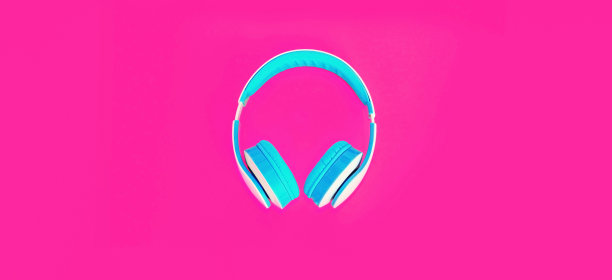 近耳机在彩色的粉红色背景，俯视图图片下载