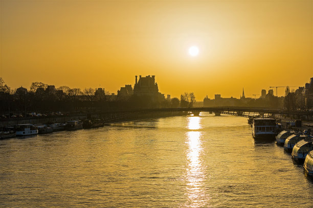 日出时巴黎塞纳河上的黄色天空和倒影图片下载