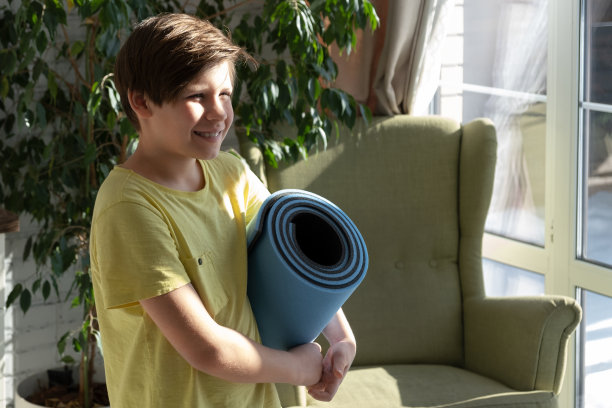 小男孩在家练习瑜伽，伸展运动，健身。远程在线教育培训，在家有氧运动。健康的生活方式，冠状病毒，呆在家里。儿童运动居家隔离图片下载