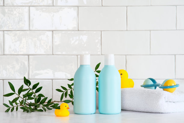 婴儿洗发精瓶子，绿叶，干净的毛巾，桌上的鸭子玩具。儿童医疗保健的概念。图片下载