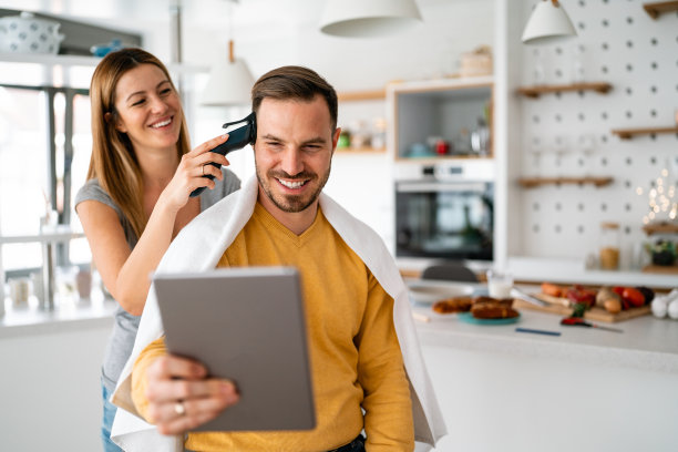 新冠肺炎疫情期间，一对夫妇在家理发，在平板电脑上在线理发图片下载