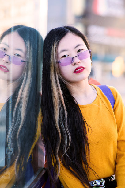 年轻的学生靠在玻璃上看着相机图片下载