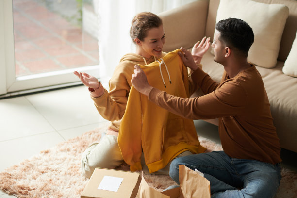 一对夫妇正在试穿订购的连帽衫图片下载