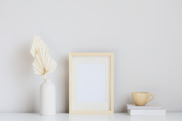 画框模板，干花花瓶，茶杯，白色桌子上的书。家居室内设计，斯堪的纳维亚风格。图片下载