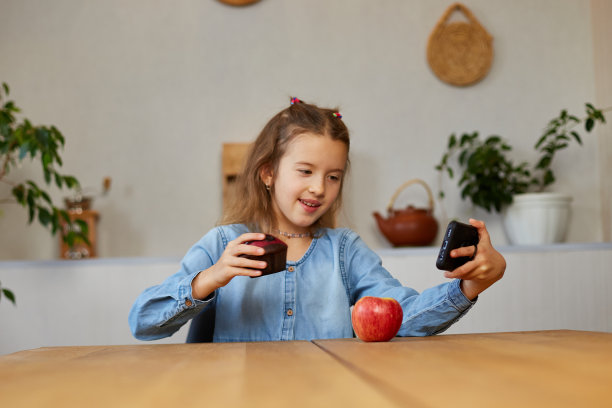 美丽的年轻女孩拍摄她的博客广播关于健康的食物在家里图片下载