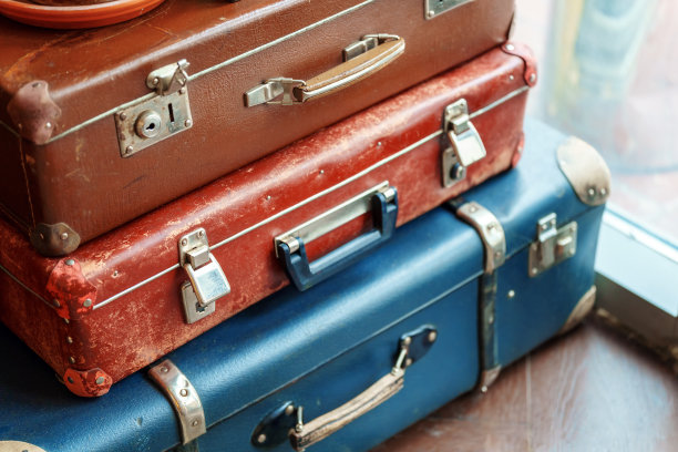 不同颜色的旧箱子摞在窗户旁边图片下载