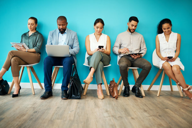 一群不同类型的商人坐在办公室里，一起使用技术图片下载