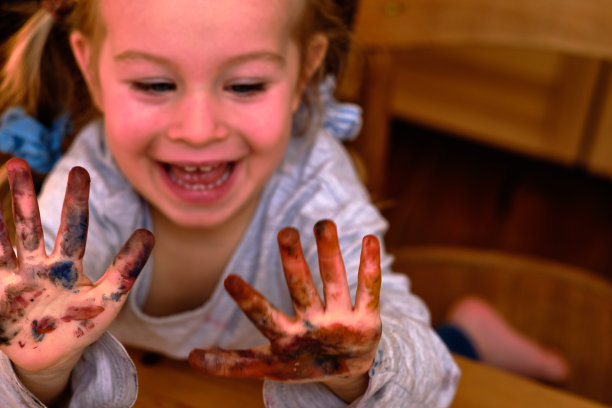 一个孩子的画像在绘画活动和她的脏手从手指画乐趣。图片下载