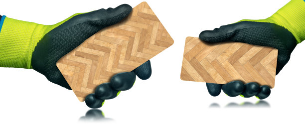 戴着手套的手拿着人字形木地板样品-隔离在白色上图片下载