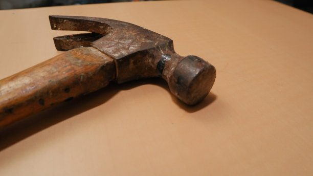 桌子上有一把生锈的木柄锤子图片下载