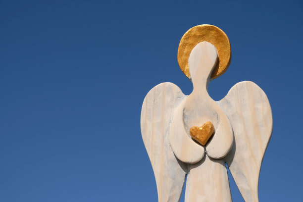 蓝色天空背景下的金色守护天使。副本的空间。图片下载