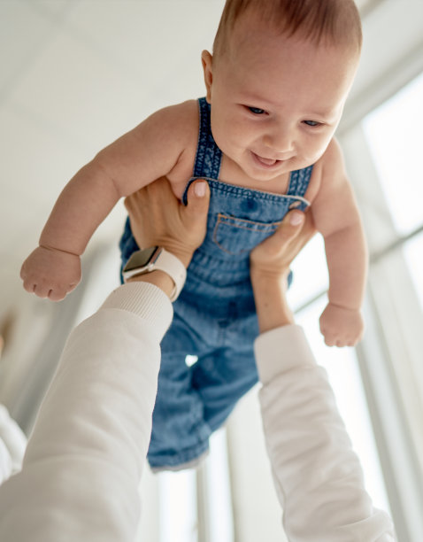 一张小男孩和妈妈在床上的家庭照片。妈妈抱着她的孩子亲吻。母亲节概念图片下载