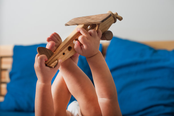 小男孩在床上玩飞机。图片下载