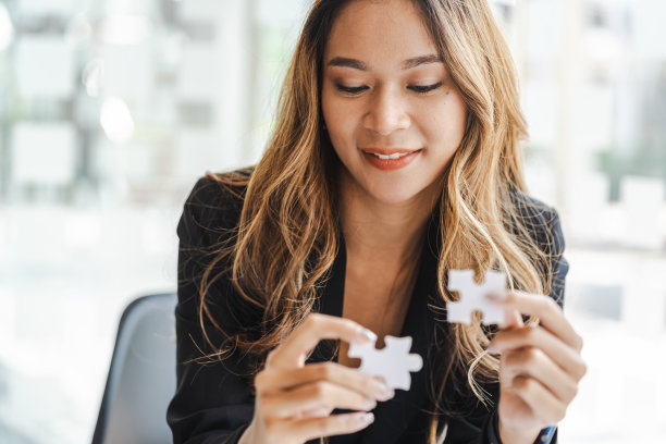 女商人在办公室用手连接拼图。业务解决方案和成功理念。图片下载