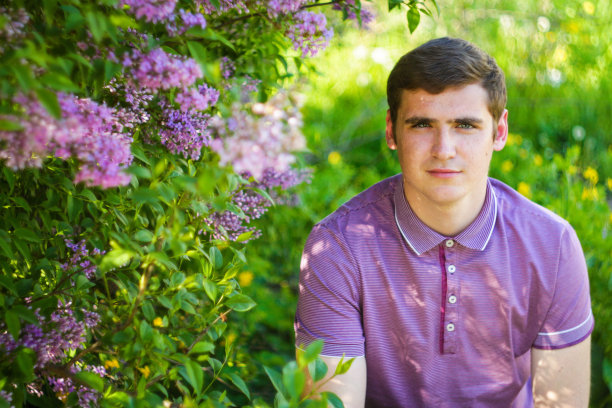 散焦白人男子户外肖像在花园。春天的人们。青年男子在紫色衬衣上自然夏天的背景。淡紫色的花。特写镜头。复古。副本的空间。20多岁。的焦点图片下载