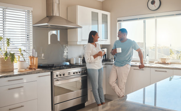 这是一对夫妇站在厨房里喝咖啡聊天的照片图片下载