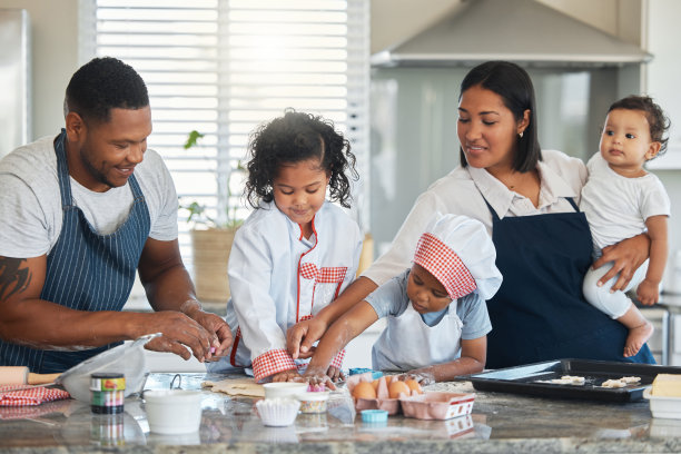 这张照片拍摄的是一对夫妇和他们的三个孩子在家里烤面包图片下载