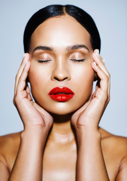 工作室拍摄的一个有吸引力的年轻女子在灰色的背景下摆姿势图片下载