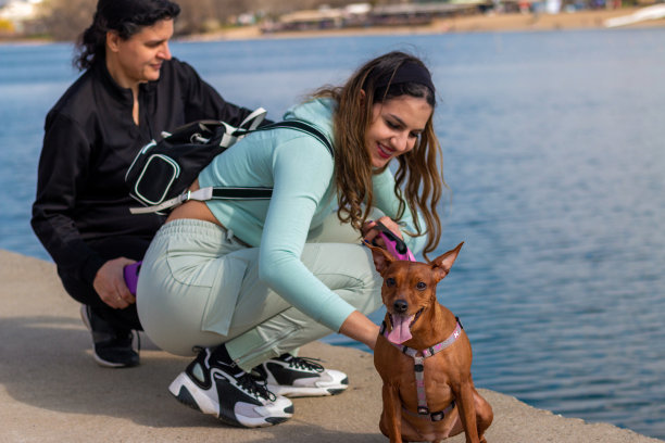 生活方式的形象，快乐的女人和她的女儿和可爱的小狗在湖边图片下载