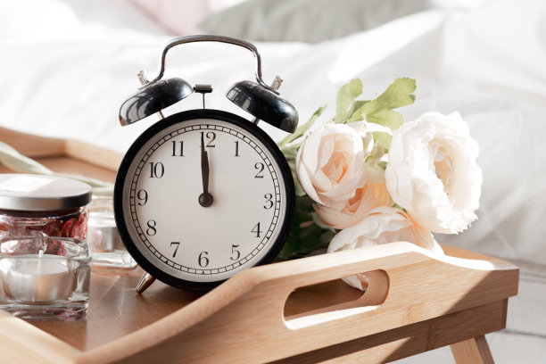 一个闹钟的特写镜头，在一个木制的花架上。爱情的感情的出现图片下载