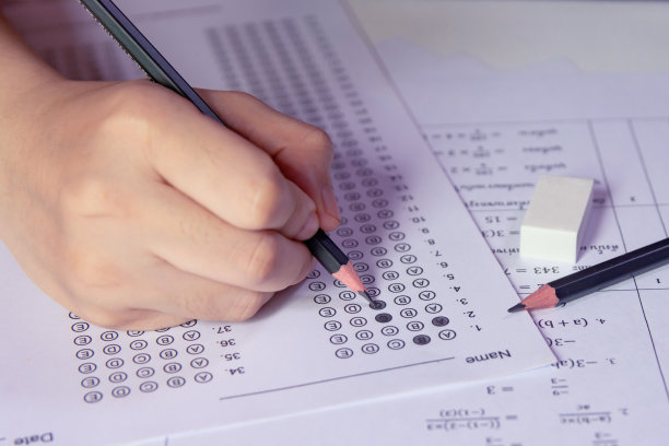 学生手持铅笔在答题纸上写下选择题图片下载