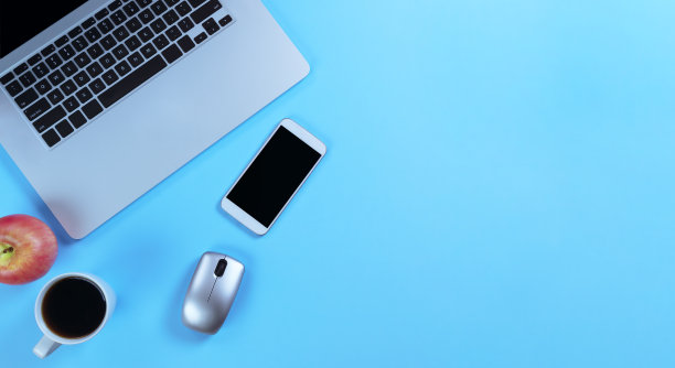 蓝色的办公桌，电脑和早餐。顶部视图与flay布局的复制空间。图片下载