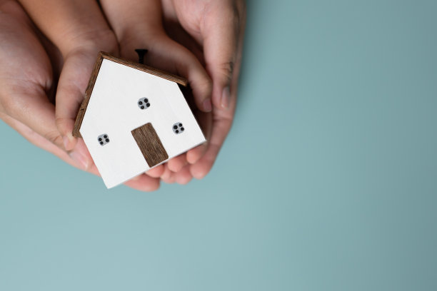 大人和小孩手牵着一间小木屋。图片下载