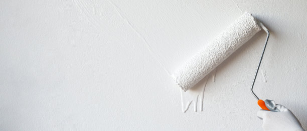 滚筒刷漆，工人刷漆，表面墙壁粉刷公寓，装修白漆。留下空的复制空间，以便在旁边写描述性文本。图片下载