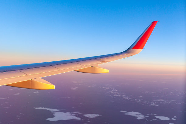 飞机飞行。通过照明器可以看到飞机的机翼和着陆图片下载