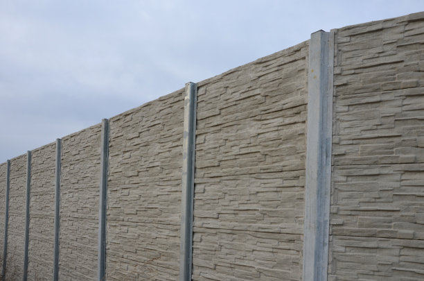 隔音墙由混凝土多孔肋材制成。灰色街区的栅栏嵌在金属梁上，在街上。道路交通噪声花园和居民区。保护耶路撒冷，火箭图片下载