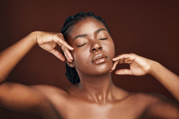 一个漂亮的年轻女子在棕色背景下摆姿势的工作室照片图片下载