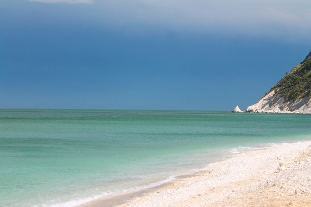 蔚蓝的亚得里亚海和Conero上的Portonovo的白色岩石上引人注目的天空图片下载