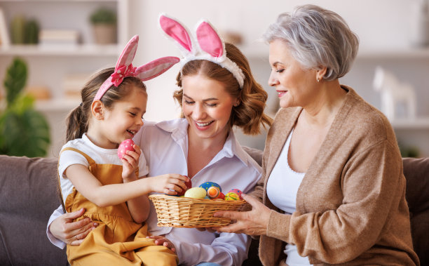 快乐的一家人在兔子耳朵里笑着，在家里玩着彩蛋，准备复活节假期图片下载