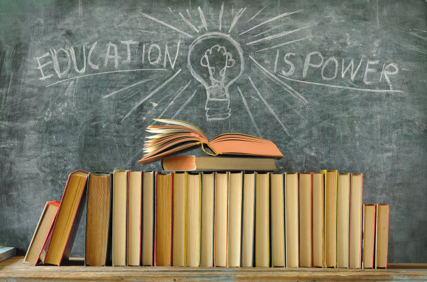 打开书本，一排书本和黑板上画着一个灯泡和标语:教育就是力量，学习，教育，回到学校的理念图片下载