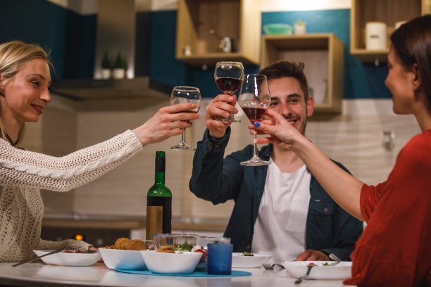 三个年轻快乐的朋友用红酒举杯庆祝图片下载